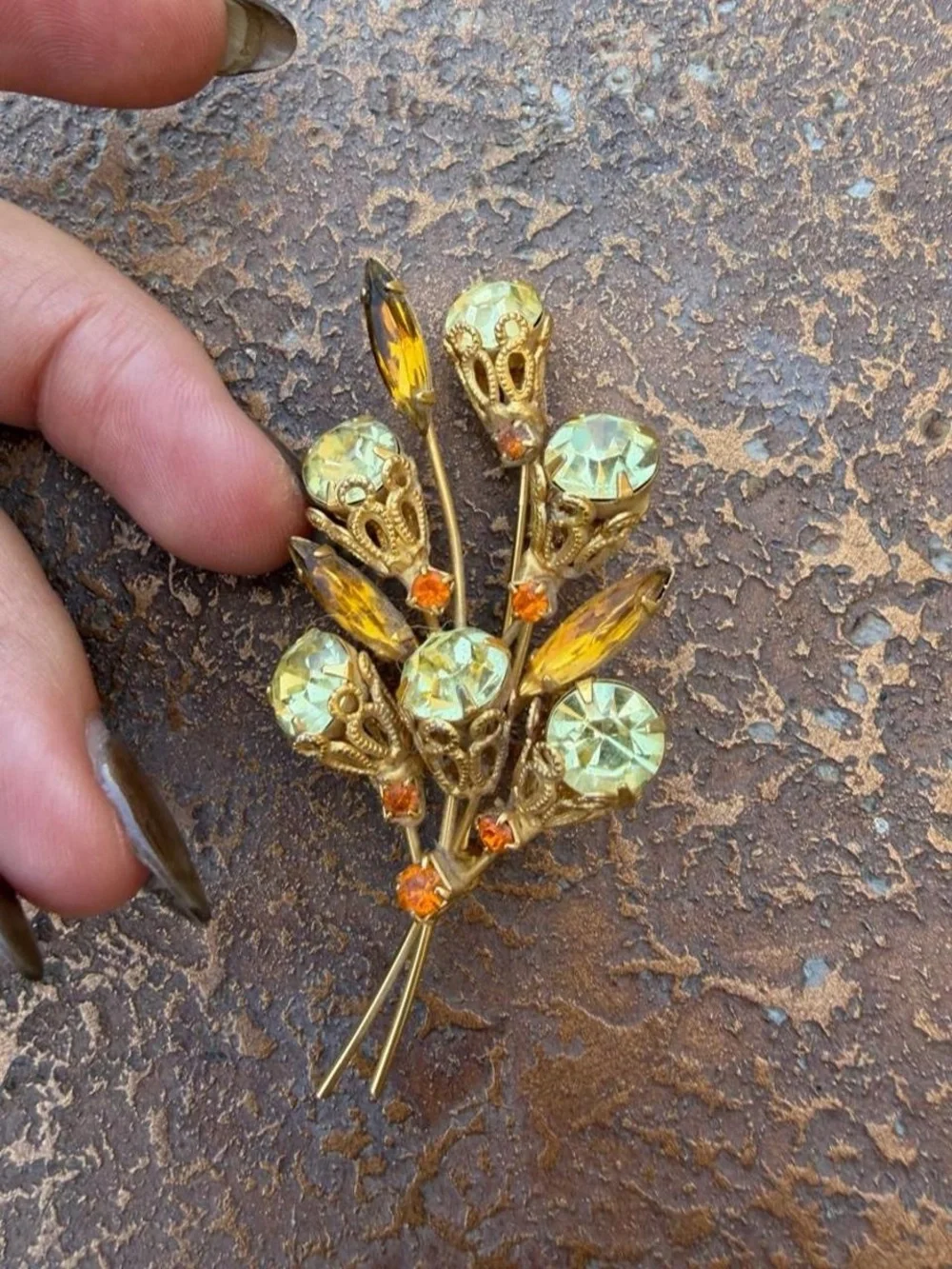 Vintage 1960s brooch with gold-tone metal and light green and orange rhinestones
